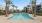 Spacious sparkling pool with sundecks and cabanas at Palms Luxury Apartments